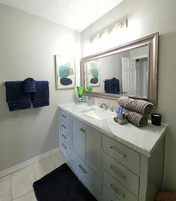 a bathroom with a sink and a large mirror at Blue By The Bay in Panama City Beach