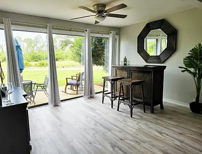 a living room with a table and chairs and a mirror at Blue By The Bay in Panama City Beach