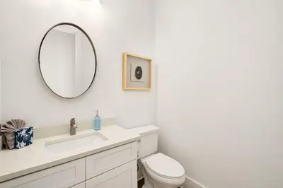 a white bathroom with a toilet and a mirror at Casa DAzure by Travel Life Vacations in Santa Rosa Beach