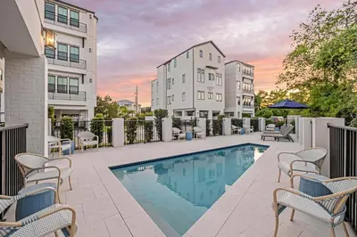 a swimming pool with chairs and a building at Casa DAzure by Travel Life Vacations in Santa Rosa Beach