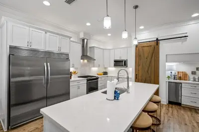 a kitchen with a stainless steel refrigerator and white cabinets at Gone Coastal by Travel Life Vacations in Seacrest