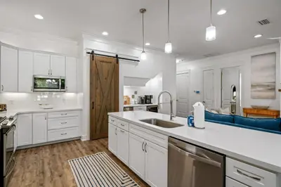 a kitchen with white cabinets and a sink at Gone Coastal by Travel Life Vacations in Seacrest