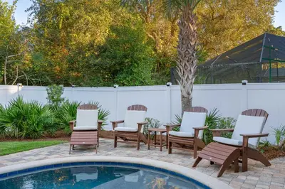 a group of chairs sitting next to a swimming pool at Gone Coastal by Travel Life Vacations in Seacrest