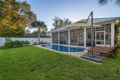 a house with a swimming pool and an umbrella at Gone Coastal by Travel Life Vacations in Seacrest