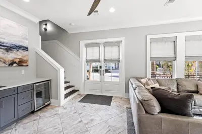 a living room with a couch and windows at Grand Pearl by Travel Life Vacations in Rosemary Beach