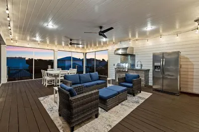 a patio with chairs and a table and a kitchen at Grand Pearl by Travel Life Vacations in Rosemary Beach