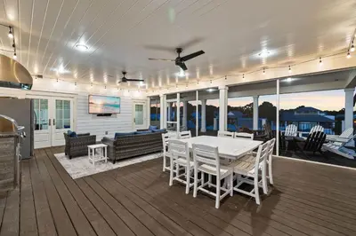 a deck with a table and chairs on a house at Grand Pearl by Travel Life Vacations in Rosemary Beach