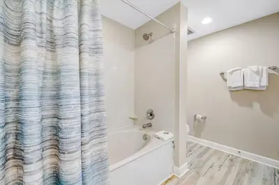 a bathroom with a tub and a shower curtain at Ocean Front Condo Panama City Beach in Panama City Beach