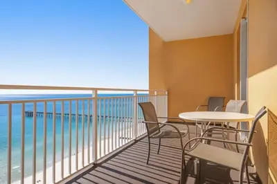 a balcony with a table and chairs and the ocean at Ocean Front Condo Panama City Beach in Panama City Beach