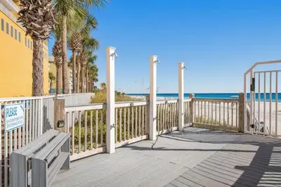 a wooden deck with a bench on the beach at Ocean Front Condo Panama City Beach in Panama City Beach