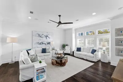 a living room with white furniture and a ceiling fan at Long To Sea by Travel Life Vacations in Santa Rosa Beach