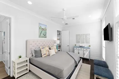 a white bedroom with a bed and a tv at Long To Sea by Travel Life Vacations in Santa Rosa Beach