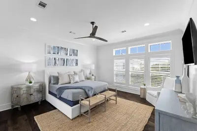 a white bedroom with a bed and a tv at Long To Sea by Travel Life Vacations in Santa Rosa Beach