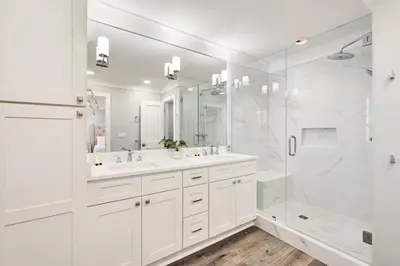 a white bathroom with two sinks and a shower at Majestic View by Travel Life Vacations in Santa Rosa Beach
