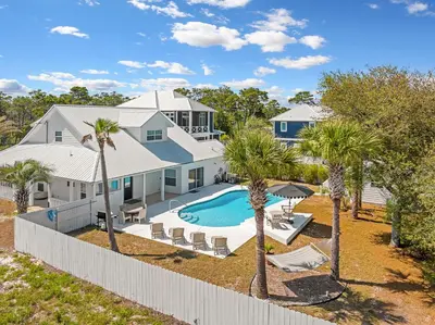 an aerial view of a house with a swimming pool and palm trees at Palm Royale by Travel Life Vacations in Inlet Beach