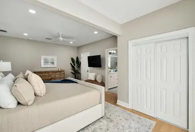 a bedroom with a bed with a white door at Palm Royale by Travel Life Vacations in Inlet Beach