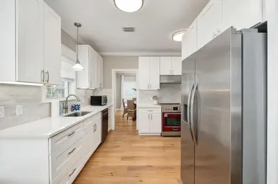 a kitchen with white cabinets and a stainless steel refrigerator at Palm Royale by Travel Life Vacations in Inlet Beach