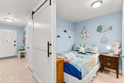 a bedroom with a bed with blue walls at Laketown Wharf #1305 in Panama City Beach