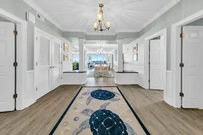 a hallway with white doors and a rug at Hidden Dunes 1605 in Panama City Beach