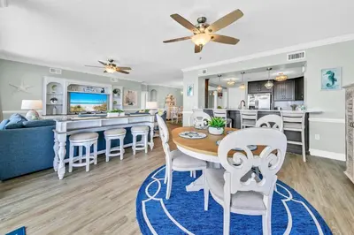 a dining room and kitchen with a table and chairs at Hidden Dunes 1605 in Panama City Beach