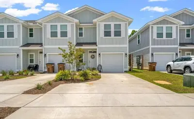 a house with a car parked in a driveway at Panama City Beach Cozy Townhouse in Panama City Beach
