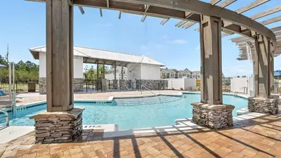 an outdoor swimming pool with a pavilion and a building at Panama City Beach Cozy Townhouse in Panama City Beach