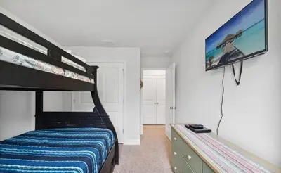 a bedroom with a bunk bed and a flat screen tv at Panama City Beach Cozy Townhouse in Panama City Beach