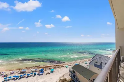 a view of the beach from the balcony of a resort at Commodore 1009 in Panama City Beach