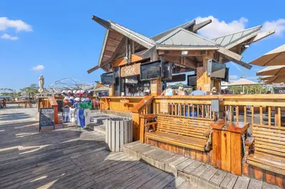 a restaurant on a boardwalk with people standing outside at Commodore 1009 in Panama City Beach