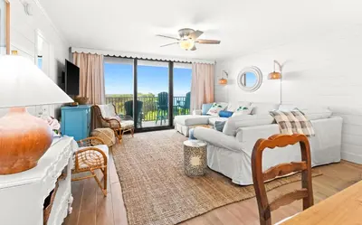 a white living room with a couch and a table at One Seagrove Place 0204 in Santa Rosa Beach