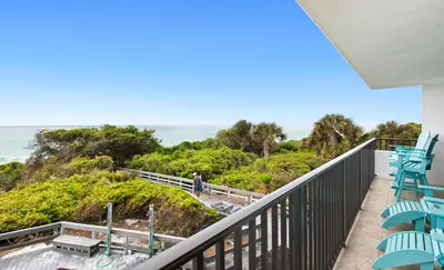 a balcony with chairs and the ocean in the background at One Seagrove Place 0204 in Santa Rosa Beach