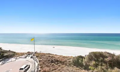 a view of a beach with a yellow flag at One Seagrove Place 0502 in Santa Rosa Beach