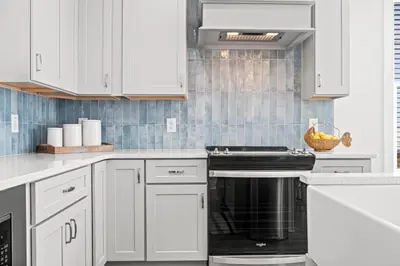 a kitchen with white cabinets and a stove top oven at Spacious 6BR Beach Home Sleeps 15 – Relax & Reconnect at Coastal Breeze in Panama City Beach