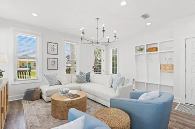 a living room with a white couch and blue chairs at Spacious 6BR Beach Home Sleeps 15 – Relax & Reconnect at Coastal Breeze in Panama City Beach