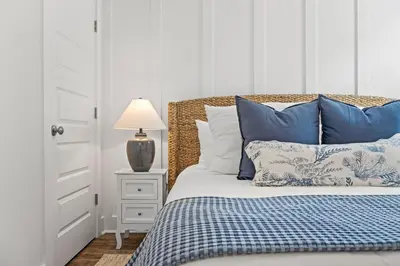 a bedroom with a bed with blue and white pillows at Spacious 6BR Beach Home Sleeps 15 – Relax & Reconnect at Coastal Breeze in Panama City Beach