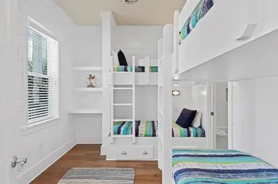 a white kids room with a bunk bed and stairs at Mermaid Cove in Inlet Beach