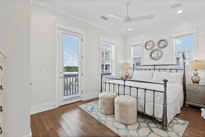 a white bedroom with a bed and two windows at Mermaid Cove in Inlet Beach