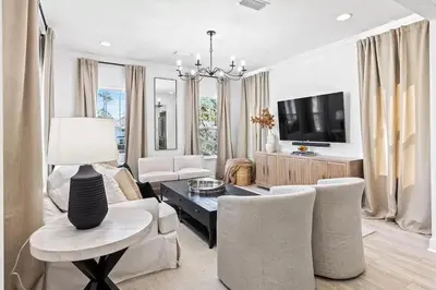 a living room with a couch and chairs and a tv at Coastal Cabana in Inlet Beach