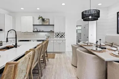 a white kitchen with a table and chairs at Coastal Cabana in Inlet Beach