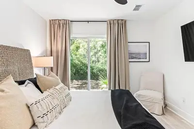 a white bedroom with a bed and a window at Coastal Cabana in Inlet Beach
