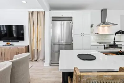 a kitchen with a refrigerator and a table with chairs at Coastal Cabana in Inlet Beach