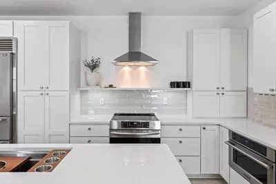 a kitchen with white cabinets and a stove top oven at Coastal Cabana in Inlet Beach