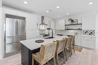 a kitchen with a large kitchen island with chairs at Coastal Cabana in Inlet Beach