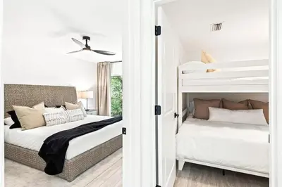 a bedroom with two bunk beds and a bedroom with a ceiling at Coastal Cabana in Inlet Beach