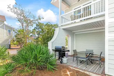 a patio with a table and chairs on a house at Coastal Cabana in Inlet Beach