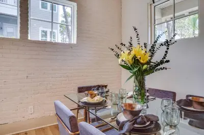 a dining room with a table with a vase of flowers at No Bad Day on 30A in Inlet Beach