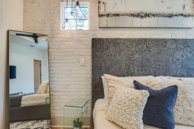 a bedroom with a brick wall with a couch and a mirror at No Bad Day on 30A in Inlet Beach