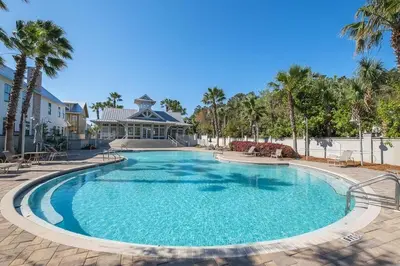 a large swimming pool with palm trees and a house at No Bad Day on 30A in Inlet Beach