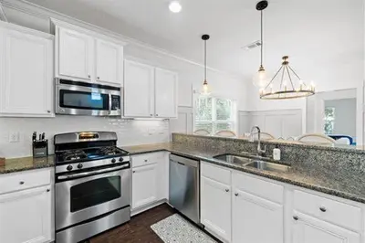 a kitchen with white cabinets and a stove top oven at Beach Bliss in Inlet Beach