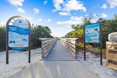 a boardwalk leading to a beach with a sign at Grandy 30A in Inlet Beach